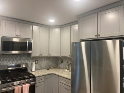 Gray shaker kitchen cabinets with stainless appliances construction project by ProWork Builders.